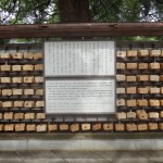 Plaques line a tree within the shrine complex where visitors request blessings